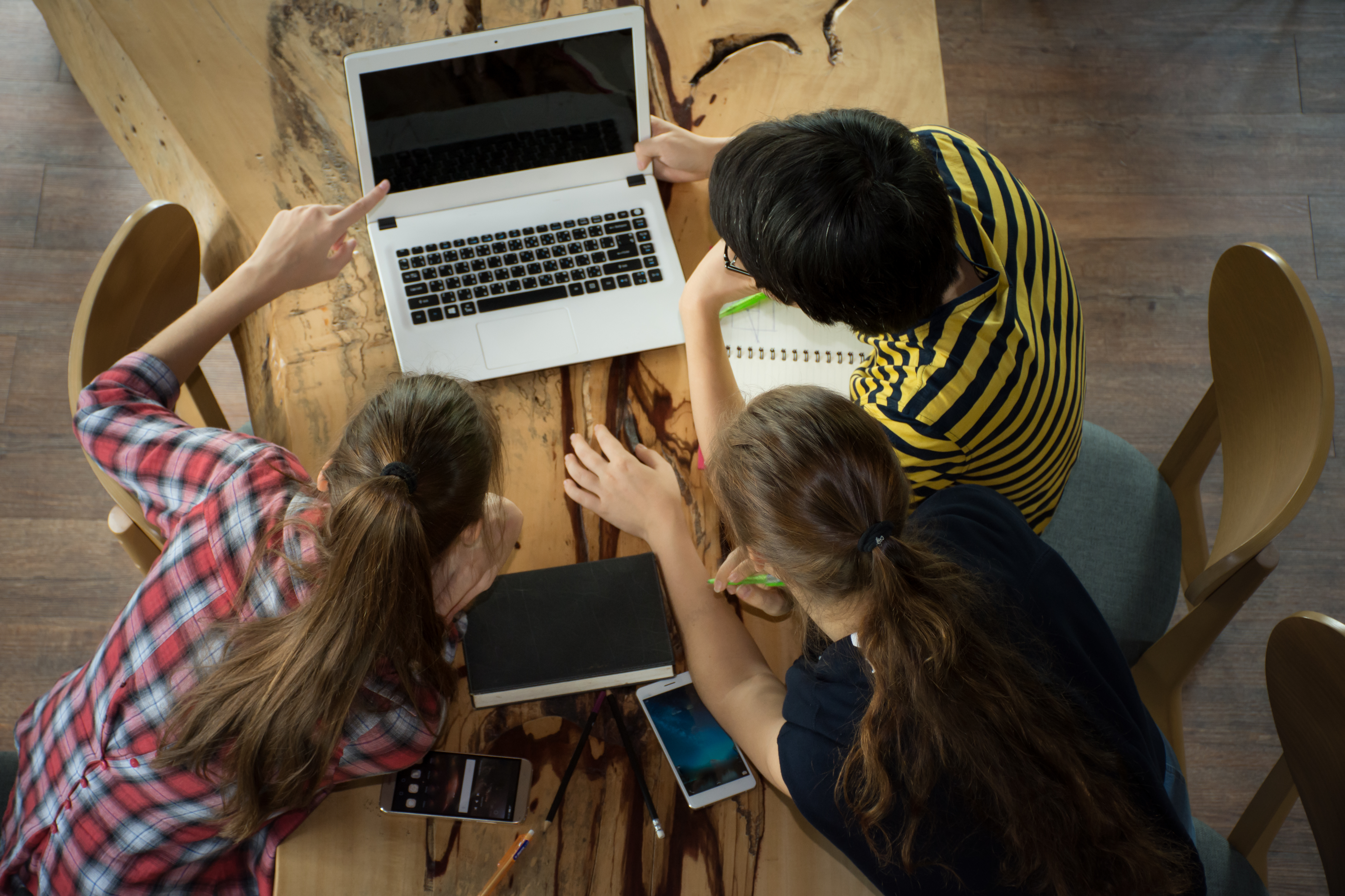 students sitting around a laptop