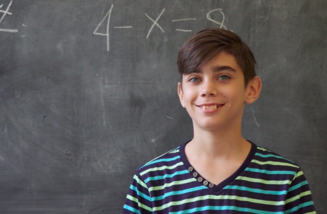 smiling student with math equation behind him