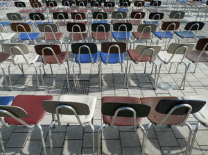 five rows of chairs lined up next to each other. mimicking rigidness of desks.