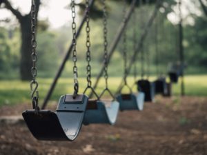 Empty swings highlighting the ways that the burden of homework prevents students from enjoying their childhood.